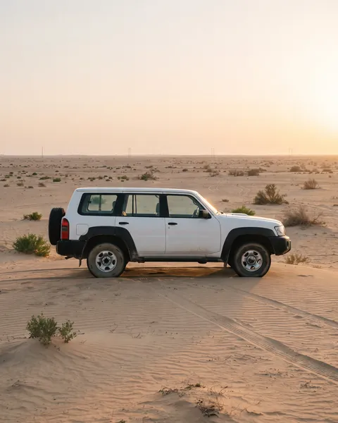 White 4x4 on the sand at sunset in the Kuwaiti desert